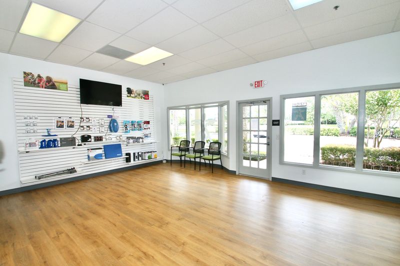 Suite 146 interior at Wilshire Plaza: front entrance, storefront windows, waiting chairs and open floor with wood-look flooring